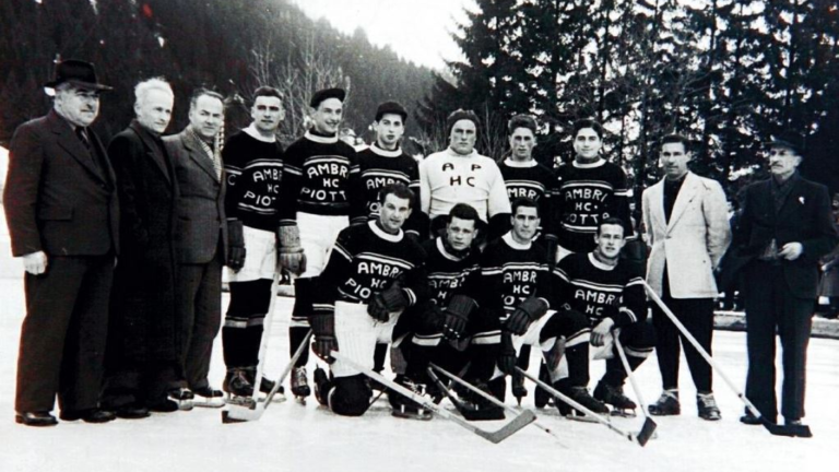 Foto storica in bianco e nero della squadra dell’HC Ambrì-Piotta con i dirigenti sul ghiaccio